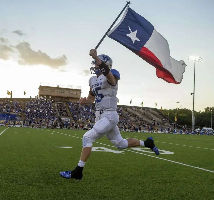 McCallum Knight runs the Texas flag at House Park